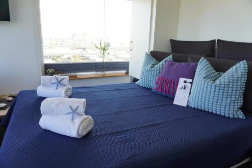 a blue bed with pillows and towels on it at Haus Belvedere Wohnung 40 in Großenbrode-Kai