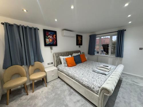 Un dormitorio con una cama y dos sillas y una ventana. en WBC R1 - Modern Large Ensuite Room - Wednesbury, en Bilston