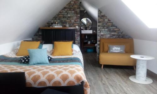 a attic bedroom with two beds and a chair at Hébergements indépendants chez l'habitant in Saint-Mars-dʼOutillé
