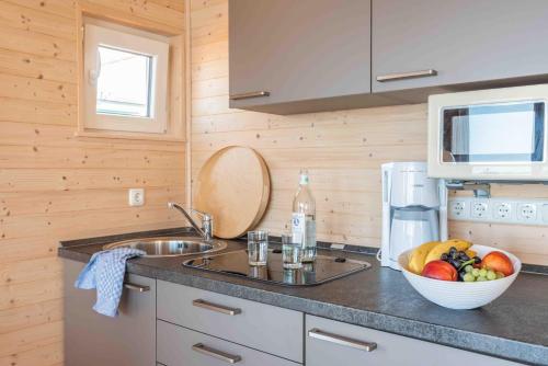 a kitchen with a bowl of fruit on a counter at Hausboot Smaragd Heiligenhafen in Heiligenhafen