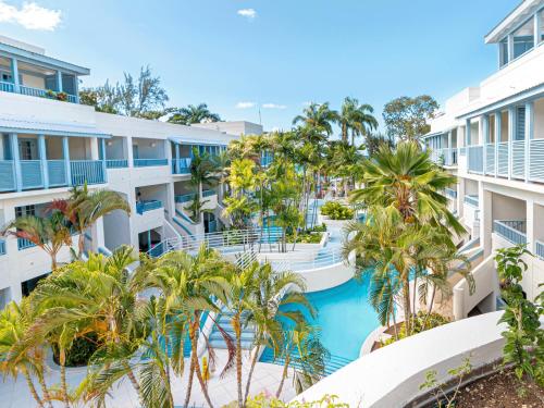 an aerial view of a resort with a pool and palm trees at Savannah Beach Club Hotel in Bridgetown