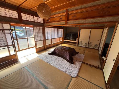 Habitación con cama en habitación con ventanas en なぎさの宿 日本文化古き良き建物畳敷 大家族グループ利用 長期滞在ok駐車場無料 日本の真ん中Mie Suzuka Ise, en Tsu