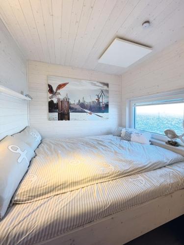 a large bed in a room with a window at STERN V Hausboot Heiligenhafen in Heiligenhafen