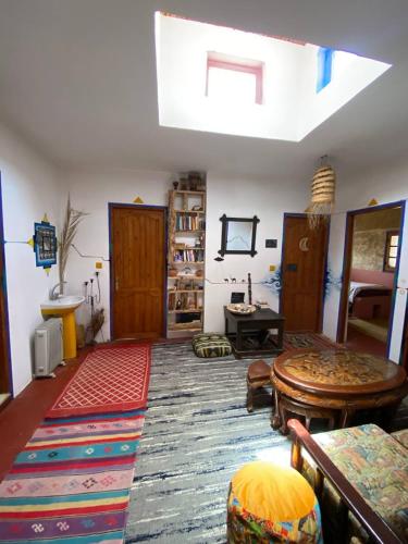 a living room with a skylight and a room with a table at Hippie Chic House in Sidi Kaouki