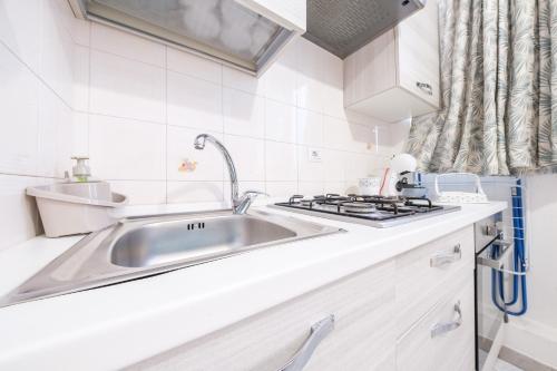 a kitchen with a sink and a stove at Casa di nonna Anna in Lipari