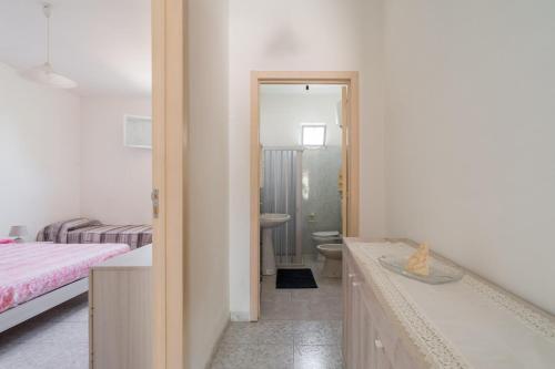 a bedroom with a bed and a bathroom with a sink at Casa Vacanze Salento in Galatone