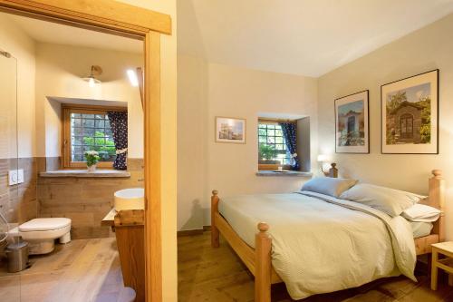 a bedroom with a bed and a bathroom with a toilet at Chalet 1175 in Arvier