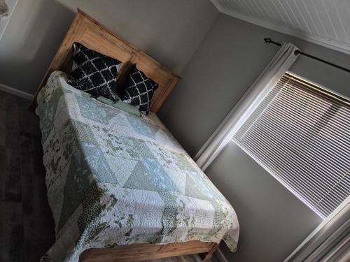 a bedroom with a bed with a quilt and a window at Remmys Place in Hawston