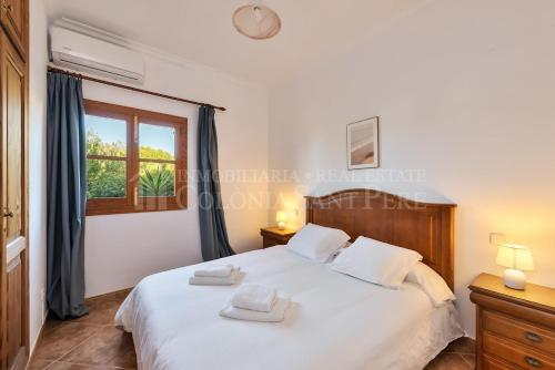 a bedroom with a large white bed and a window at Casa en Montferrutx in Colonia de Sant Pere