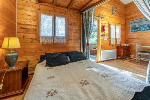 a bedroom with a bed in a log cabin at Chalet gite in Saint-Paulet-de-Caisson