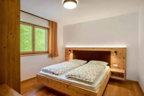 a bedroom with a bed with a wooden headboard at Bachwiesl Hof Apt Pichl in Proves