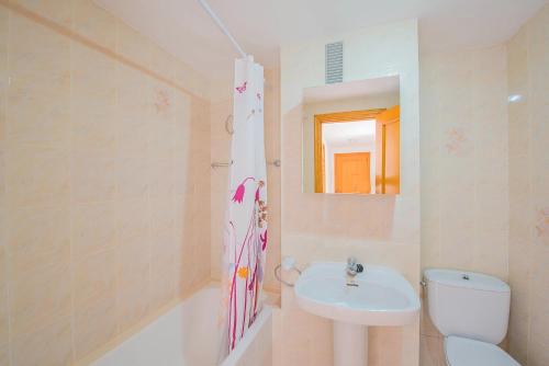 a bathroom with a sink and a toilet and a mirror at Apartamento Zeus - PlusHolidays in Calpe