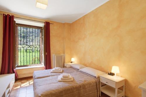 a bedroom with a bed with two towels on it at Casa Tua - Avise in Avise