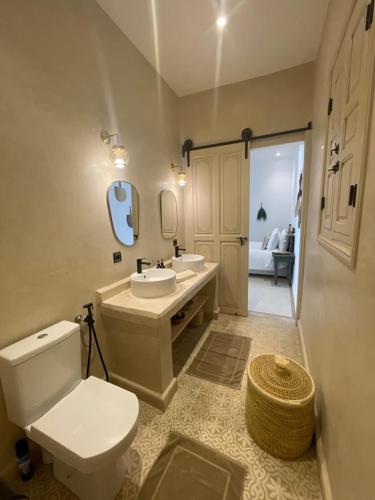 a bathroom with a toilet and a sink and a mirror at Riad 4 chambres, Piscine chauffée, Petit déjeuner inclus in Marrakesh