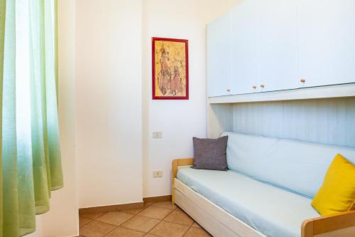 Un sofá azul en una habitación con ventana. en Ruggeri - Casa Rosa, en Castiglione della Pescaia