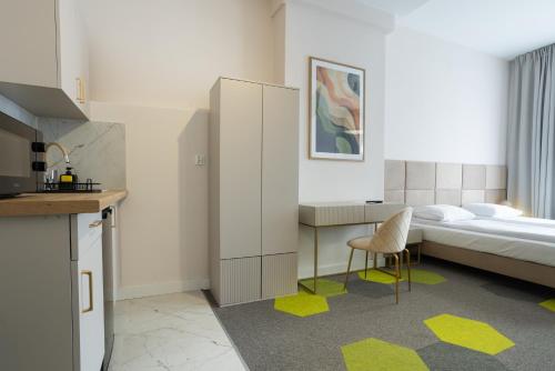 ein Schlafzimmer mit einem Bett, einem Schreibtisch und einem Stuhl in der Unterkunft Moon Apartments Wrocław in Breslau