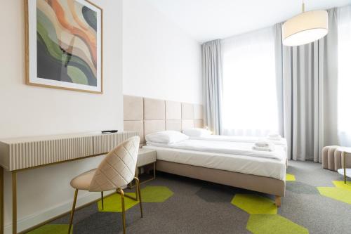 ein Hotelzimmer mit einem Bett und einem Stuhl in der Unterkunft Moon Apartments Wrocław in Breslau