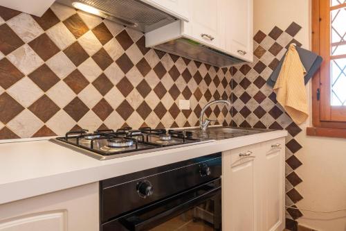 una cocina con estufa y fregadero en Villa Gle Apt 1, en Quartu SantʼElena