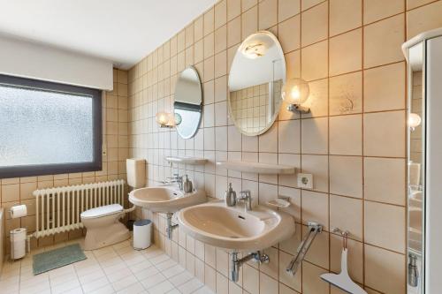LanggönsにあるFerienwohnung Rositaのバスルーム(洗面台2台、トイレ付)
