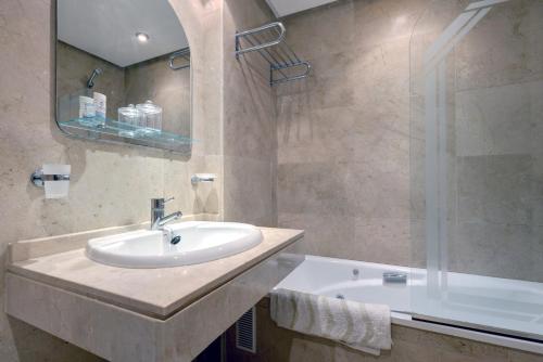 un baño con lavabo y bañera en La Terraza del Mar, en Manilva