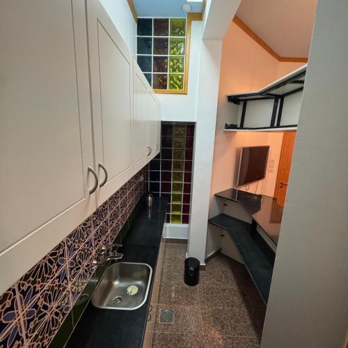 a small kitchen with a sink and a counter at Qurum Heights Hotel in Muscat