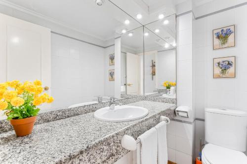 a white bathroom with a sink and a mirror at Ático con terraza in Torrevieja