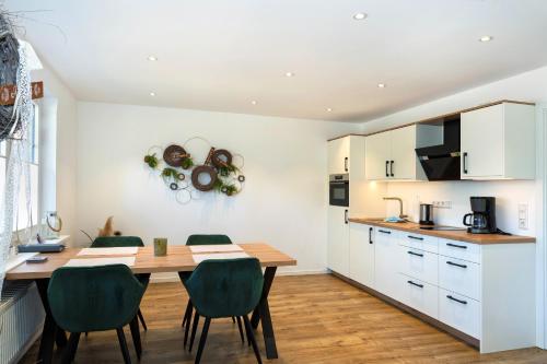 eine Küche und ein Esszimmer mit einem Holztisch und Stühlen in der Unterkunft Klosterhof Aue W 3 in Bad Zwischenahn