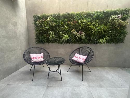 two chairs and a table with pink pillows on them at El Taller de San Martín in Águilas