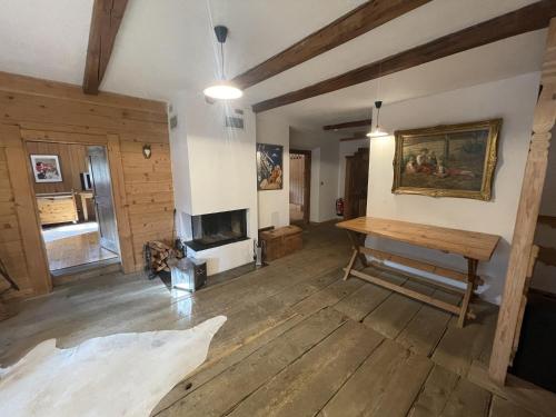 StuhlfeldenにあるGeigerhaus 500 Jahre - Maisonetteのテーブルと暖炉のあるリビングルーム