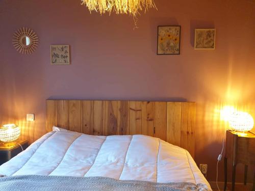 1 dormitorio con 1 cama grande con 2 luces. en La Chambre de la Ferme du Clos Giot, en Saint-Vaast-la-Hougue