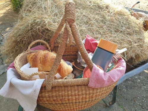 Una cesta con pan y un libro sobre una mesa en La Chambre de la Ferme du Clos Giot, en Saint-Vaast-la-Hougue