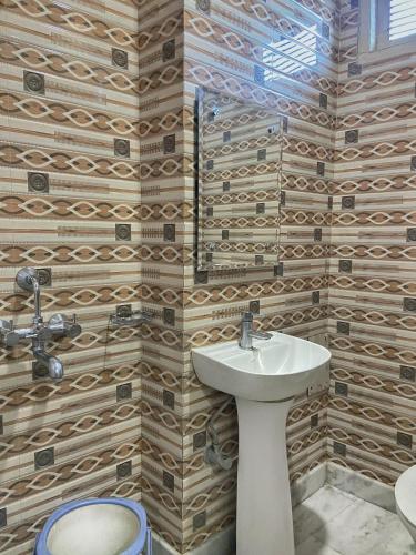 a bathroom with a sink and a toilet at Ashoka Residency in Katra