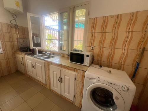 a kitchen with a washing machine and a microwave at Mpita 2 in Pointe-Noire