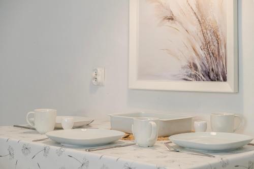una mesa con dos tazones blancos y tazas en ella en 5 Apart, en Gdynia