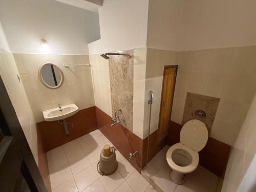 a small bathroom with a toilet and a sink at Downtown in Manipala