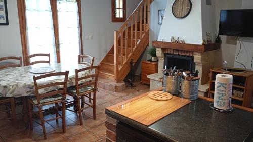 ein Wohnzimmer mit Tisch und Kamin in der Unterkunft Le Pressoir in Cresseveuille