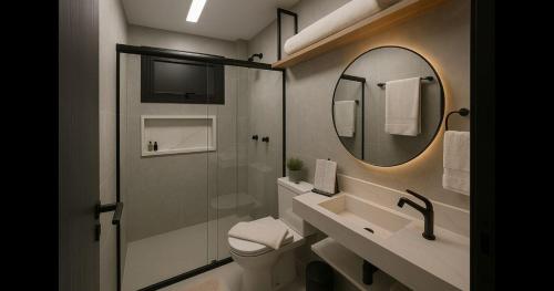a bathroom with a toilet and a sink and a mirror at Studio lindíssimo Vila do Lago- 900m da vila in Praia do Forte