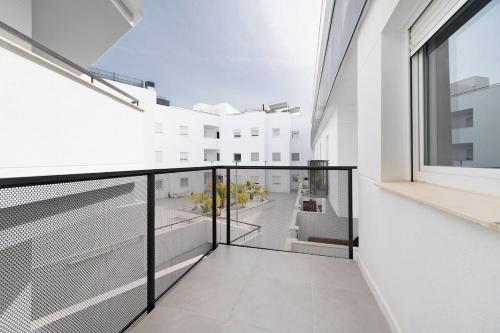 トレ・デ・ベナガルボンにあるDreamy Beach Duplexの白い壁のバルコニー、大きな窓が備わります。