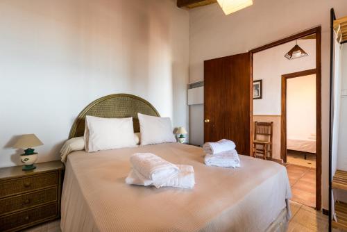 a bedroom with a bed with two towels on it at Casa del Pipa con vistas al mar in Benajarafe