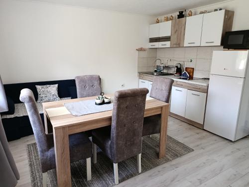 - une cuisine avec une table et des chaises en bois dans l'établissement Apartman Branka, à Niška Banja