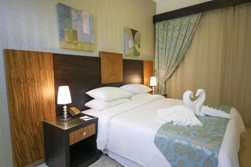 a hotel room with a bed with swans on it at Ivory Grand Hotel Apartments in Dubai