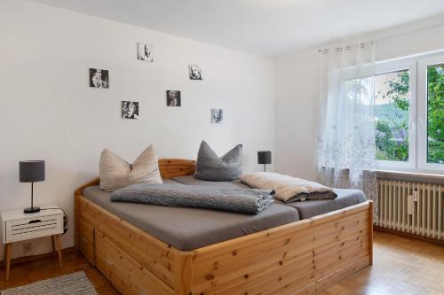 ein Schlafzimmer mit einem Holzbett mit Kissen darauf in der Unterkunft Ferienresidenz Gartentraum Titisee in Titisee