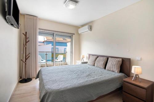 een slaapkamer met een groot bed en een balkon bij Numar Residence A C in Vila Nova de Cacela