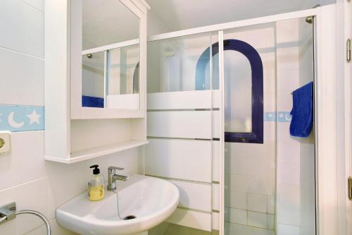 マスパロマスにあるMeloneras 1の洗面台とシャワー付きの白いバスルーム