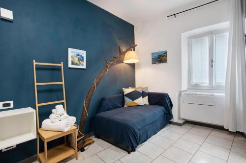 un salon avec un mur d'accent bleu et une chaise dans l'établissement Ca Du Grifun 2, à Vernazza