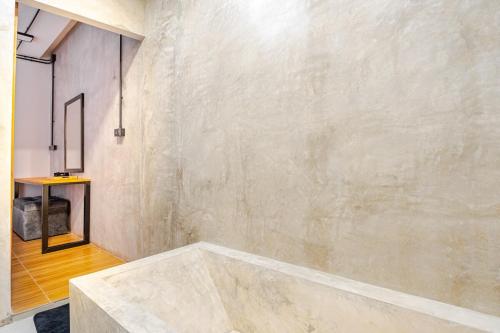 ein Badezimmer mit einer großen Betonwand in der Unterkunft Cactus Villa 2024, Krabi in Klong Muang Beach