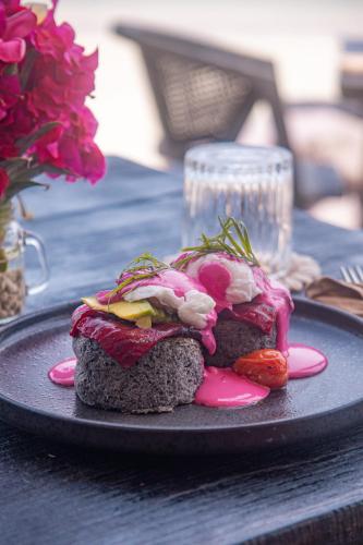 Ein schwarzer Teller mit zwei Sandwiches auf einem Tisch in der Unterkunft Hakuna Matata Resort Gili Air in Gili Air