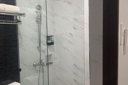 a shower with a glass door in a bathroom at Madison Suites in Lapu Lapu City