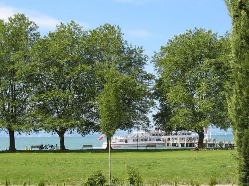 a boat in a field with trees and the ocean at Withum - Nonnenhorner Straße 13 in Kressbronn am Bodensee