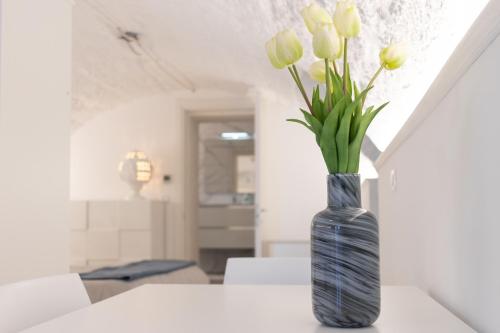 a vase with yellow tulips in it on a table at La Porta Sul Mare- Timone in Mola di Bari